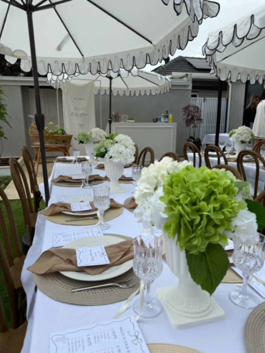 Editorial Melbourne event styling — cream baby shower tablescape with florals and fabric signage